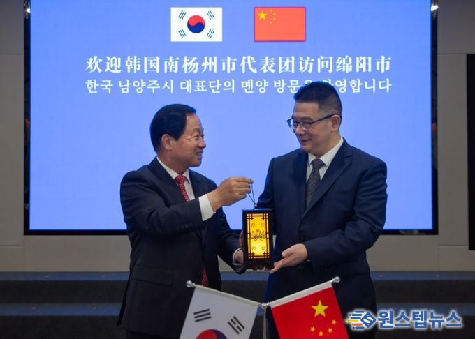 주광덕 남양주시장(좌)이 리원 몐양시장(우)에게 기념품을 전달하고 있다.