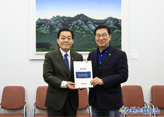 이재준 수원시장(왼쪽)이 신정훈 국회 행정안전위원장에게 건의문을 전달하고 있다.