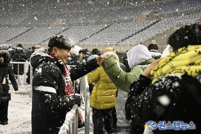 부천FC1995의 승강 PO 1차전이 폭설로 연기된 후 돌아가는 시민들과 조용익 부천시장이 주먹인사를 나누고 있다.