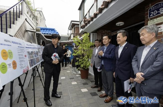 수원시와 한국보훈복지의료공단이 수원지역 독립유공자 후손의 집수리를 지원한 새빛하우스 앞에서 관계자들이 사업 설명을 듣고 있다.