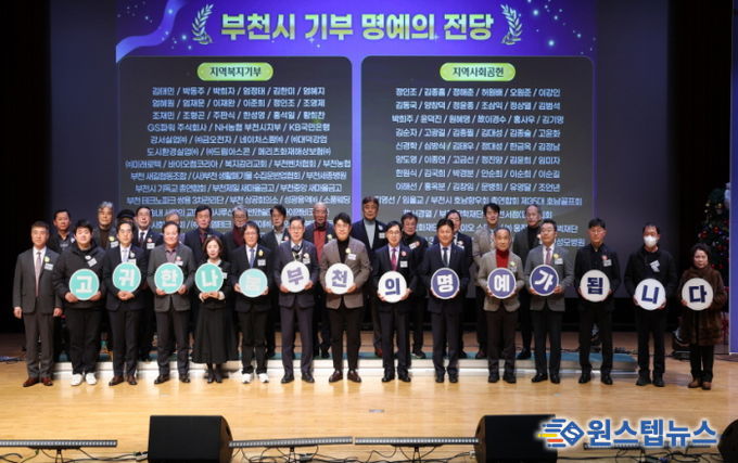 명예의 전당 등재자들과 부천시장이 종무식 무대에서 기념사진을 찍고 있다.