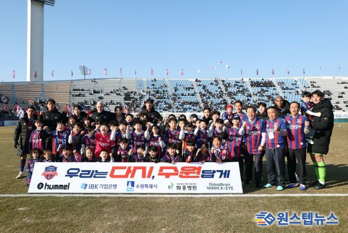 이재식 수원특례시의회 의장을 비롯한 내빈들과 어린이들이 「2026 시즌 K리그2 수원FC 홈 개막전」을 앞두고 기념촬영을 하고 있다.