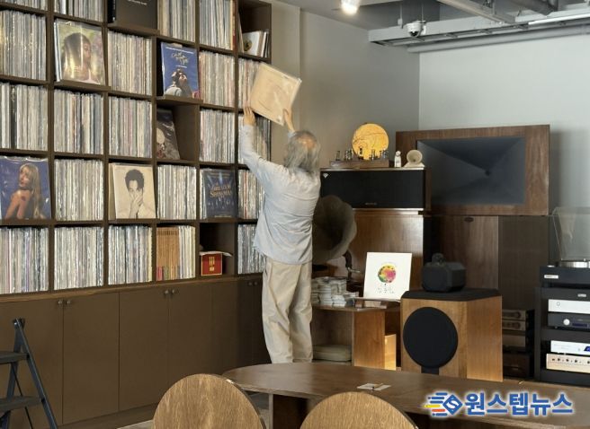 음악감상실 온 주인장이 신청곡 LP를 찾고 있다.