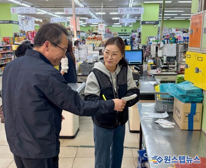 사장이 종량제봉투 주문 수량 확인 후 수령 확인증을 건네 받고 있는 모습