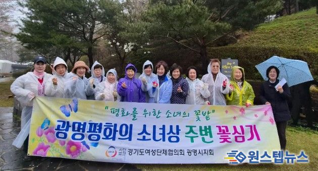 광명시 여성단체협의회가 10일 광명동굴 입구에 설치된 평화의 소녀상 주변에 봄꽃 300그루를 심고 기념사진을 촬영하고 있다.